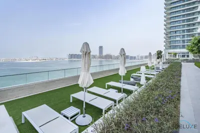 a row of chaise lounges and umbrellas on a roof at Inviting 1BR at Beach Vista Tower 1 Emaar Beachfront Dubai Marina by Deluxe Holiday Homes in Dubai