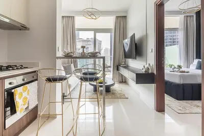 a kitchen with two chairs and a kitchen with a bed at Frank Porter - Reva Residences in Dubai