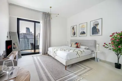 a white bedroom with a bed and a large window at GuestReady - Mesmerizing views of the Burj Khalifa in Dubai