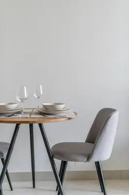 a wooden table with chairs and plates and glasses at GuestReady - Mesmerizing views of the Burj Khalifa in Dubai