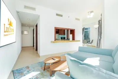a living room with a blue couch and a table at Lux BnB Burj Views Tower I Downtown in Dubai