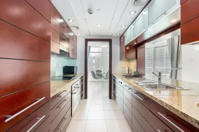 a kitchen with wooden cabinets and a sink at Lux BnB Burj Views Tower I Downtown in Dubai