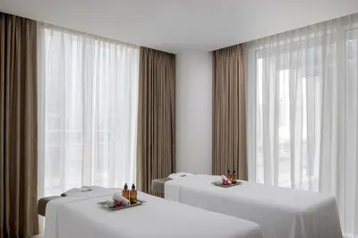 a room with three tables with white sheets and windows at Staybridge Suites Dubai Business Bay by IHG in Dubai