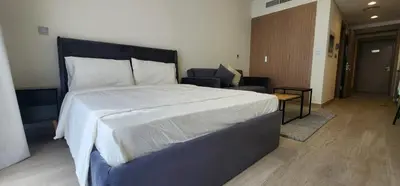 a bedroom with a large bed and a living room at Luxury Studio, 15m to Dubai Mall! in Dubai