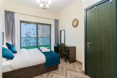a bedroom with a bed and a desk and a window at Contemporary furnishing I City skyline view in Dubai
