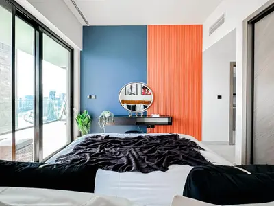 a bedroom with a blue and orange wall at Trophy - Luxury Canal View Suites. in Dubai