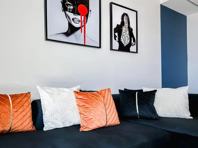 a black couch with orange and white pillows on it at Trophy - Luxury Canal View Suites. in Dubai
