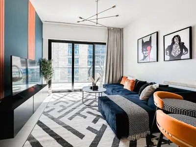 a living room with a blue couch and a table at Trophy - Luxury Canal View Suites. in Dubai
