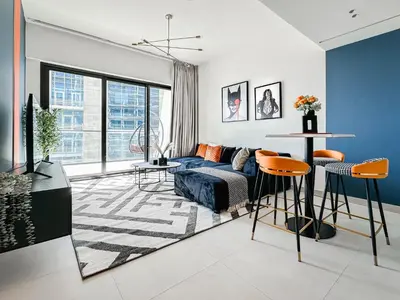 a living room with a couch and a table at Trophy - Luxury Canal View Suites. in Dubai