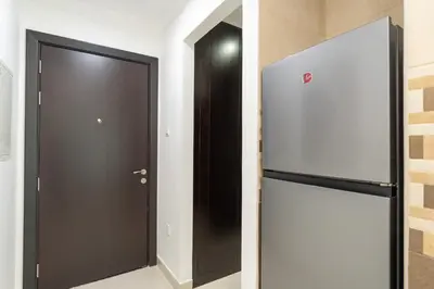a black door in a room with a refrigerator at Comfortable Broad Studio in Business Bay-Suiteable in Dubai