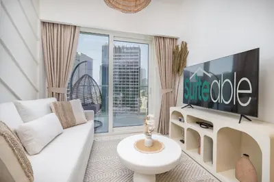a living room with a white couch and a flat screen tv at Business Bay Bliss 1 bedroom apartment - Suiteable in Dubai