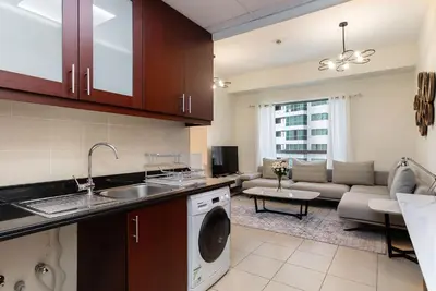 a kitchen and living room with a washer and dryer at Excellent 1BR Apertments at Bahar 6 in Dubai