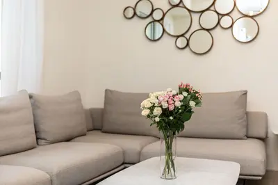 a vase of flowers on a table in front of a couch at Excellent 1BR Apertments at Bahar 6 in Dubai