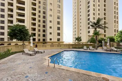 a swimming pool in the middle of two tall buildings at Excellent 1BR Apertments at Bahar 6 in Dubai