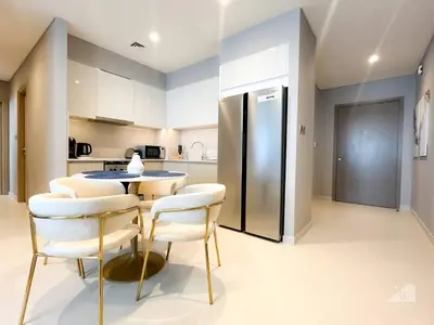 a kitchen with a table and chairs and a refrigerator at NEW! Modern Elegance 2B in Burj Royale Downtown in Dubai