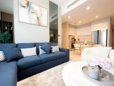 a living room with a blue couch and a table at NEW! Modern Elegance 2B in Burj Royale Downtown in Dubai