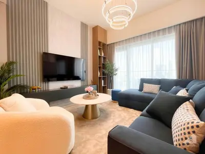 a living room with a blue couch and a tv at NEW! Modern Elegance 2B in Burj Royale Downtown in Dubai