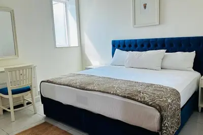 a bed with a blue headboard in a bedroom at The Sand Castle- Pinnacle tower, Dubai Marina, Near metro in Dubai