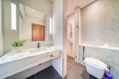 a bathroom with a sink and a toilet and a mirror at Central Park Towers, City View - DIFC - Mint Stay in Dubai