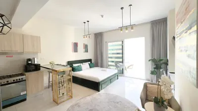 a kitchen and living room with a bed in a room at Ahlan HH - Charming Studio at AG Tower in Dubai