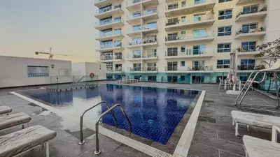 a large swimming pool in front of a building at Ahlan HH - Charming Studio at AG Tower in Dubai