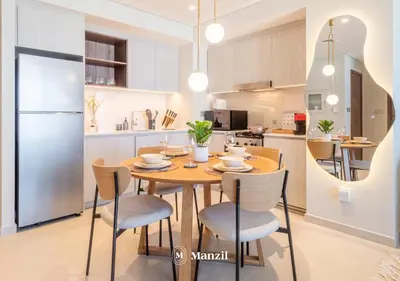 a kitchen and dining room with a wooden table and chairs at Manzil - Sleek 1BR Home in Dubai Creek with Beach & Marina Access in Dubai