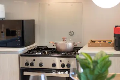 a pot on top of a stove in a kitchen at Manzil - Sleek 1BR Home in Dubai Creek with Beach & Marina Access in Dubai
