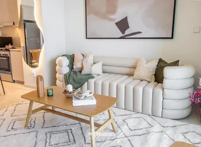 a living room with a white couch and a table at Manzil - Sleek 1BR Home in Dubai Creek with Beach & Marina Access in Dubai