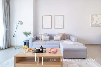 a living room with a blue couch and a coffee table at LUX LIV Contemporary Full Marina View Suite in Dubai