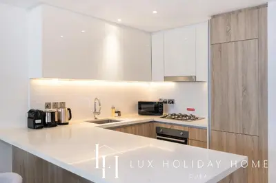 a kitchen with white cabinets and a white counter top at LUX LIV Contemporary Full Marina View Suite in Dubai