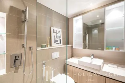 a bathroom with a shower and a sink and a mirror at LUX LIV Contemporary Full Marina View Suite in Dubai
