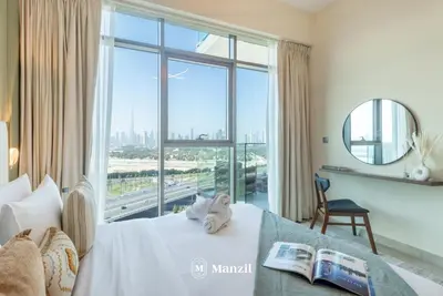 a bedroom with a bed with a large window at Azizi Farhad in Dubai