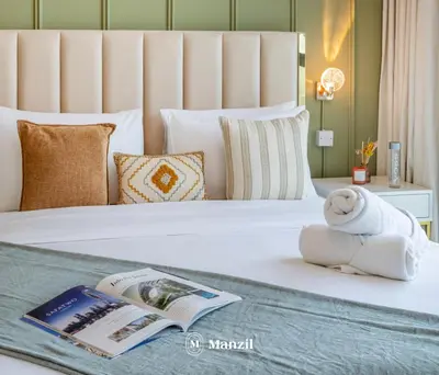 a hotel room with a book and a towel on a bed at Azizi Farhad in Dubai