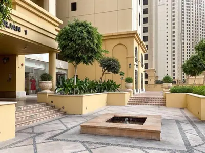 a building with a fountain in the middle of a courtyard at Spacious 4BR Apartment in JBR next to the Beach in Dubai