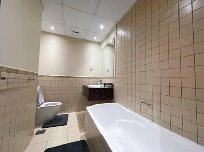 a bathroom with a tub and a toilet and a sink at Spacious 4BR Apartment in JBR next to the Beach in Dubai