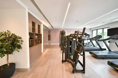 a gym with treadmills and a row of exercise bikes at Burj Royale-Enchanting Burj&Fountain full view Sky APT 3+1BR in Dubai