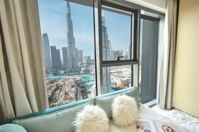 a couch in front of a window with a city view at Burj Royale-Enchanting Burj&Fountain full view Sky APT 3+1BR in Dubai