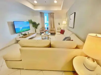 a living room with a couch and a tv at Your Cosy Dubai Marina Home in Dubai