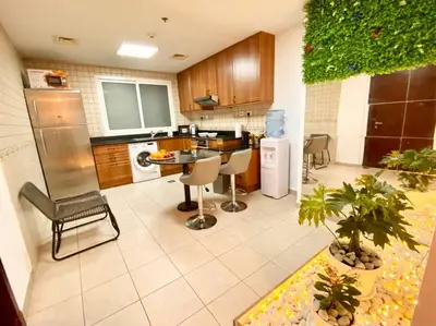a large kitchen with a table and chairs in it at Your Cosy Dubai Marina Home in Dubai