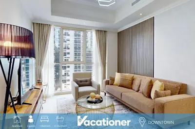 a living room with a couch and a table at Vacationer l Premium One Bed I Walk to Dubai Mall, Burj Khalifa I Dunya Tower Downtown in Dubai
