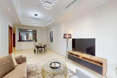a living room with a couch and a tv at Vacationer l Premium One Bed I Walk to Dubai Mall, Burj Khalifa I Dunya Tower Downtown in Dubai