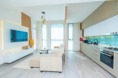 a large living room with a couch and a kitchen at Midtown Haven Cozy One Bed in Dubai in Dubai