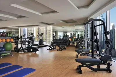 a gym with a lot of treadmills and machines at Luxury Address Res Dubai Marina Studio in Dubai