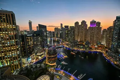 a city skyline at night with a river and buildings at Luxury Address Res Dubai Marina Studio in Dubai