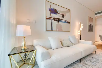 a living room with a white couch and a glass table at Address JBR with Sea View & Maid Room - Mint Stay in Dubai