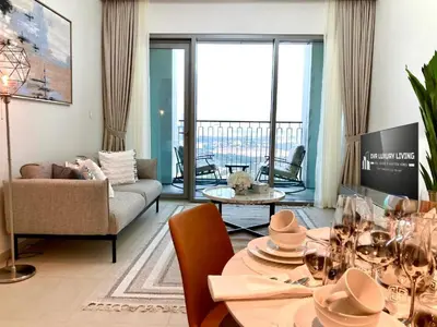 a living room with a table and a couch at Luxurious 1-bedroom With Skyline View In Downtown Views Ii in Dubai