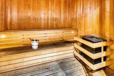 a wooden sauna with a bucket and a cup in it at Amazing 1 BD in Marina Gate 2 Dubai Marina in Dubai