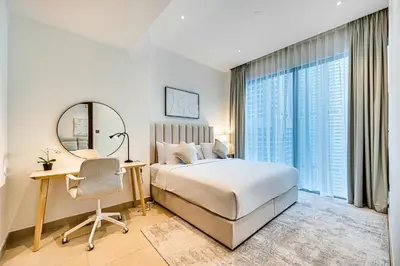 a bedroom with a bed and a desk and a mirror at Amazing 1 BD in Marina Gate 2 Dubai Marina in Dubai