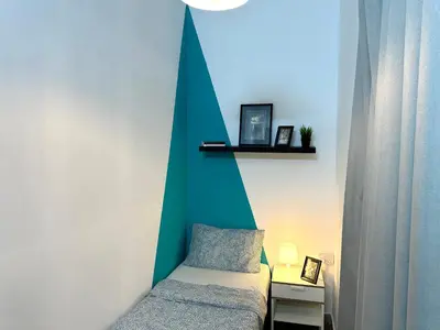a bedroom with a bed and a green wall at Cityview Partition Room with Balcony in Tecom in Dubai