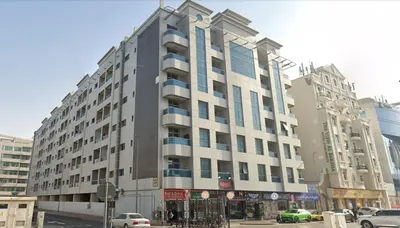 a large building on a city street with cars at Prime Partition Room in Al Barsha 1 Near Metro in Dubai